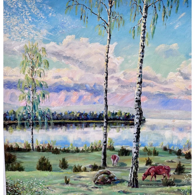 Vintage serene landscape oil painting depicting cows grazing by sea, with birch trees and fluffy clouds with pink accents....
