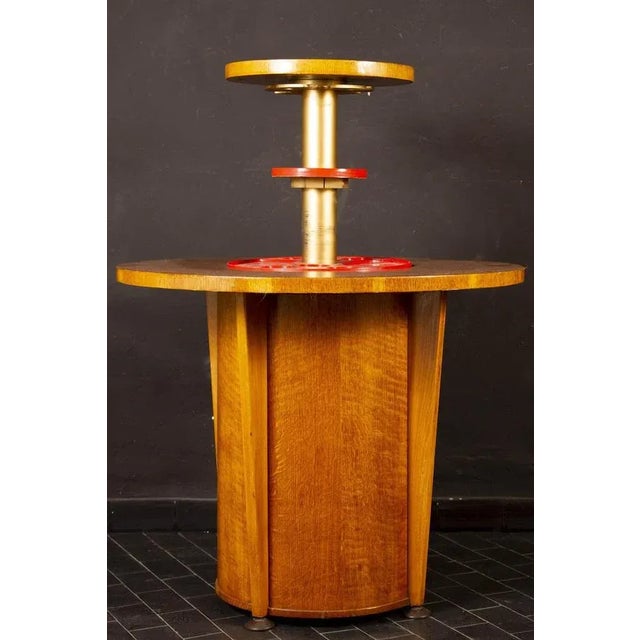 Mid-century curious bar table with the central retractable mechanism.