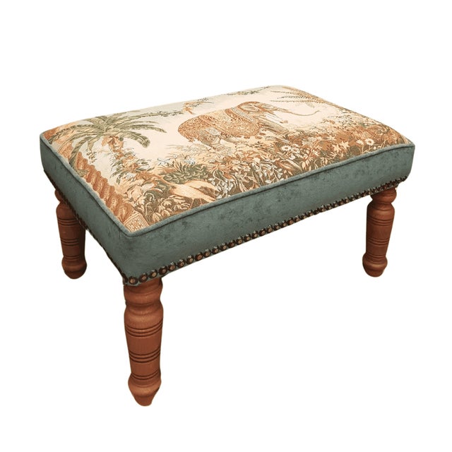 Meticulously handcrafted in the United Kingdom, this upholstered stool boasts classic studding and hand-polished solid...