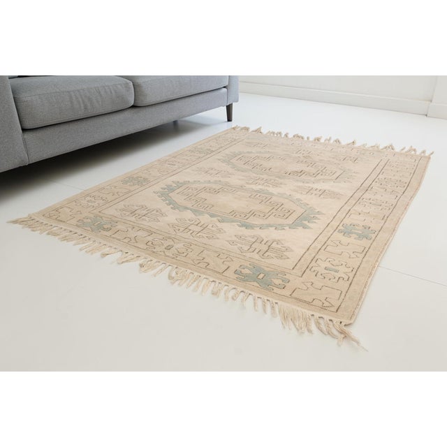 This is a vintage Turkish Oushak rug from the Mid 20th Century. The piece was hand-knotted.