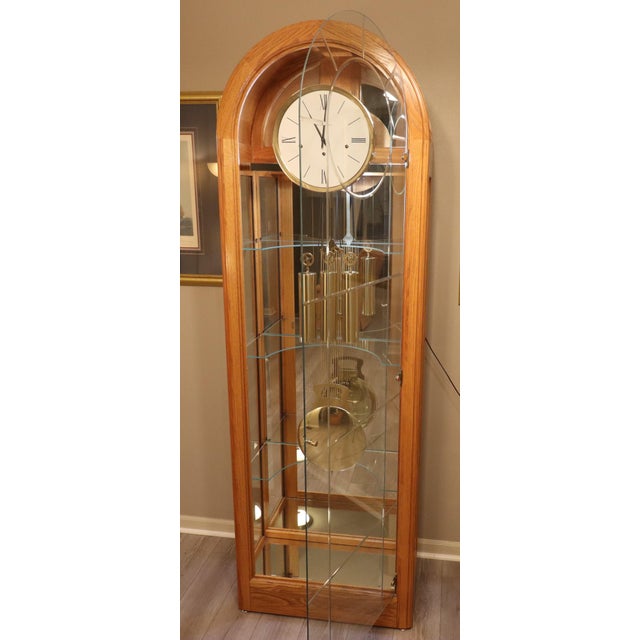 A refined example of late 20th-century American horology, this Howard Miller “Eternity II” curio grandfather clock (Model...