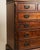 A striking Chippendale-style highboy featuring a beautifully carved scroll pediment with a central finial and intricate...
