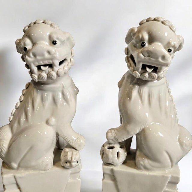 Lovely pair of white Chinese made ceramic foo dogs. 1960's vintage, produced by Wai Ming and signed underneath the base of...