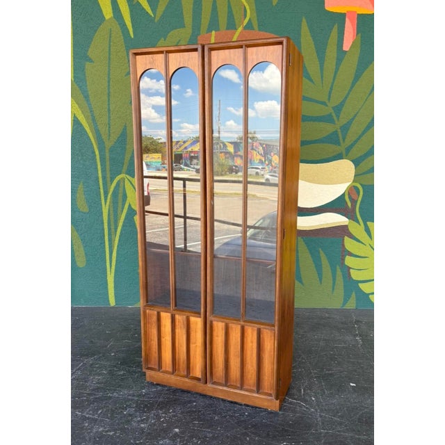 Timeless classic in this hutch. Walnut veneers and arched panels to accent the illuminated case and display your prized...