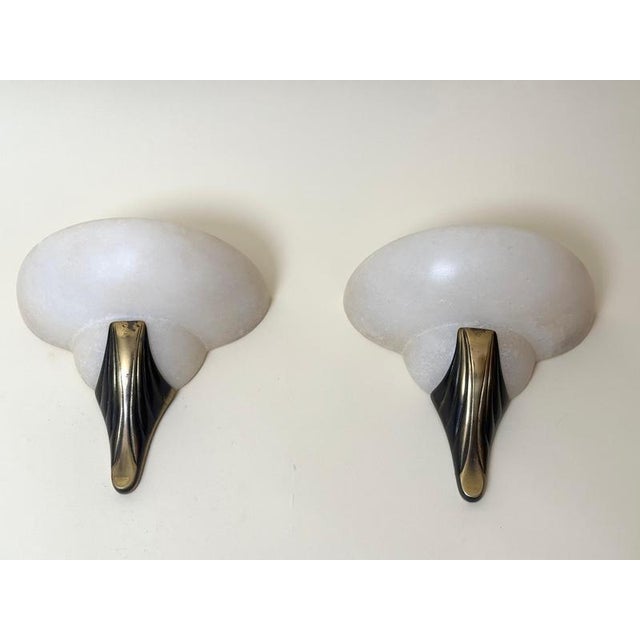 Elegant pair of handcrafted alabaster wall sconces in the Art Deco Revival style, dating from approximately the late 1980s...