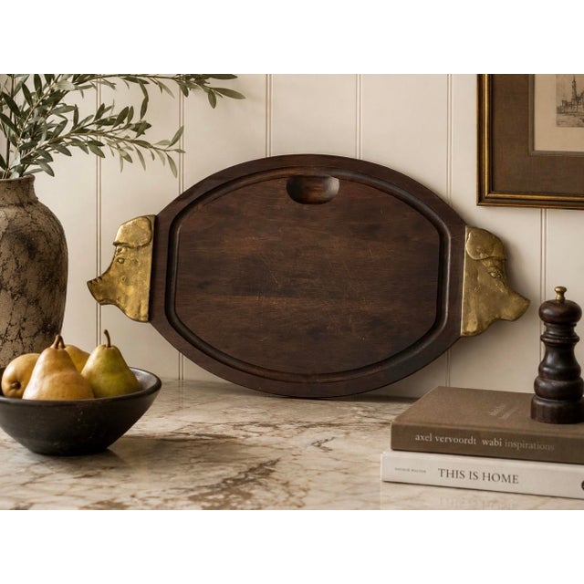A striking vintage Mid-Century Modern carving and serving board featuring richly grained dark hardwood accented by...