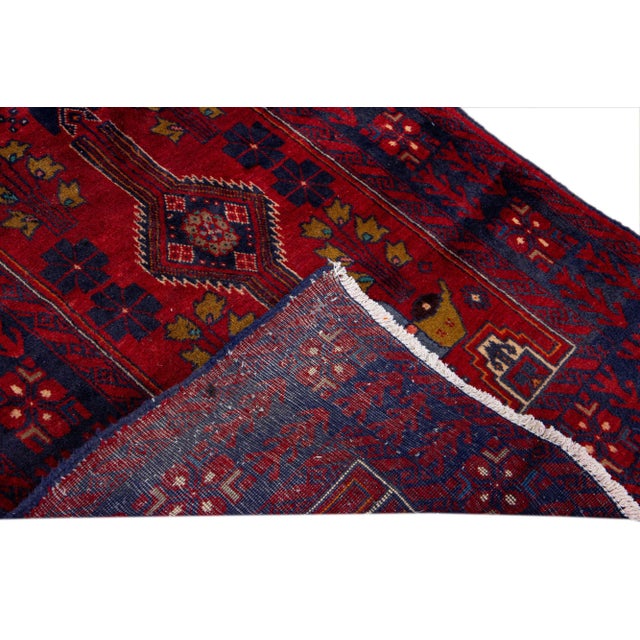Beautiful Vintage Persian hand-knotted Wool runner rug with the red field. This Persian rug has a multicolor accents in...