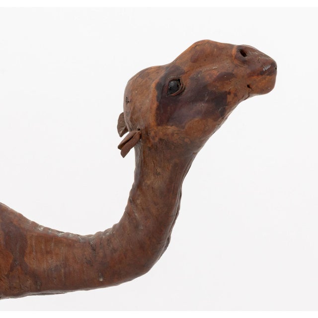 Standing Camel Leather Covered Sculpture, 20th century, with inset glass eyes. 12.75" H x 14" W x 4" D. Provenance: The...