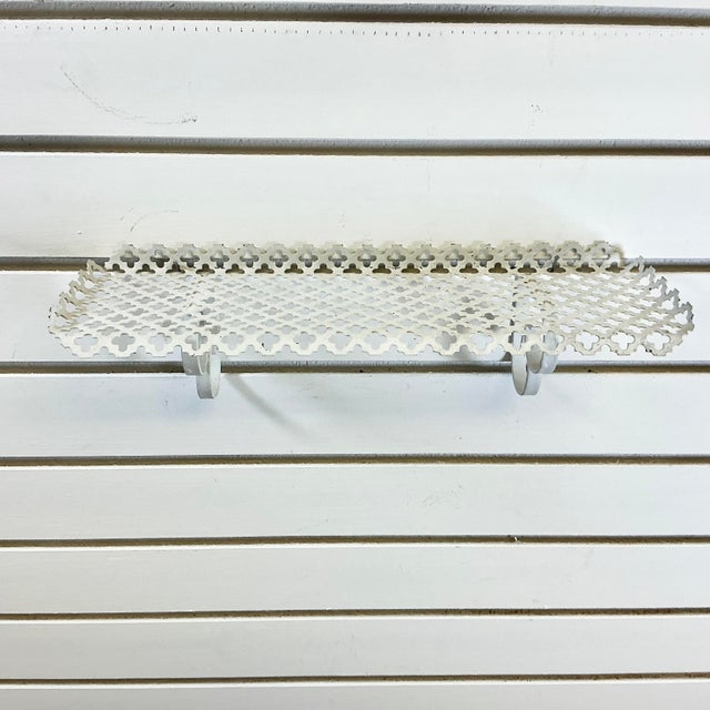 A great Mid-Century find. This pierced Metal Wall Shelf is a classic vintage style featuring two curled metal brackets....