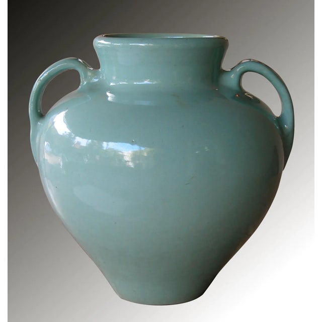A large-scaled American pottery aqua-glazed double-handled urn; the flaring neck above an ovoid body flanked by loop handles