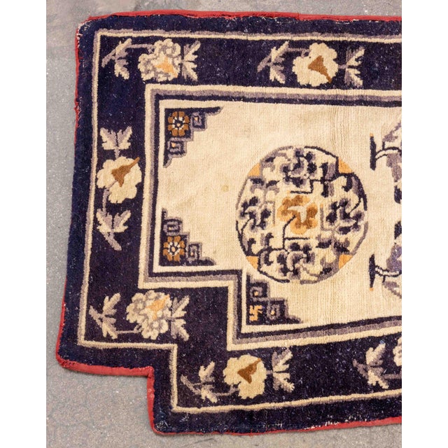 Chinese Wool Saddle Rug, in blue and cream with floral motif and red trim. 4' 6" L x 2' 1" W. Provenance: From a 45 East...