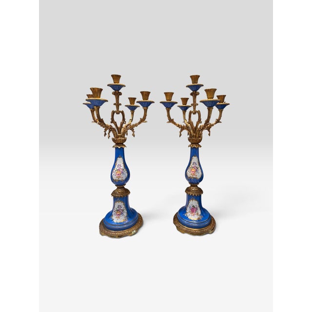 Elegant matched pair of French five-light candelabra featuring richly colored cobalt-blue porcelain bodies decorated with...