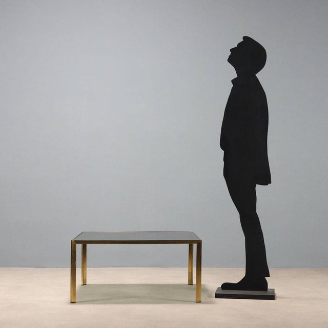 Vintage coffee table with square smoked glass top and brass frame. This piece is attributed to the mentioned...