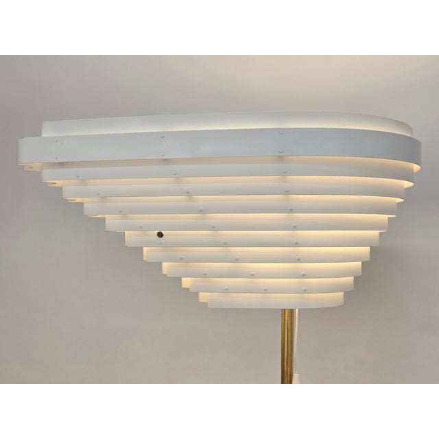 Artek A805 floor lamp "Angel's Wing", manufactured by Valaisinpaja, designed by Alvar Aalto. The lamp has a brass base,...
