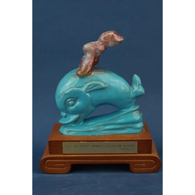 A stunning sculpture in full Futurist style, depicting a cherub riding a dolphin, entirely handcrafted and modeled by the...