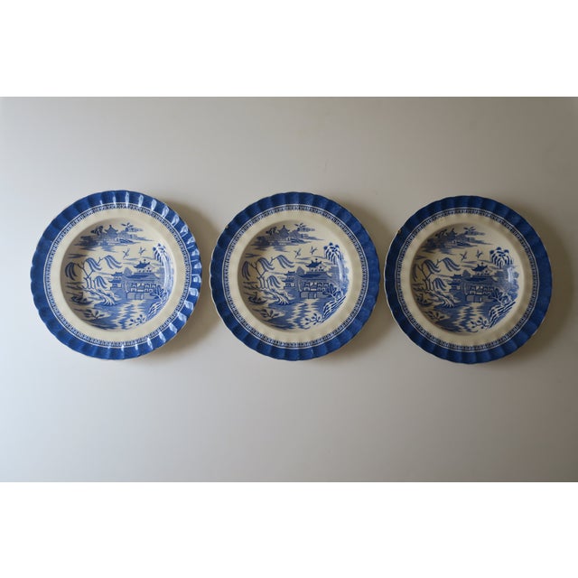 An English set of three (3) cobalt‑blue and off‑white ironstone soup plates, in a Chinoiserie landscape pattern, by W. T....