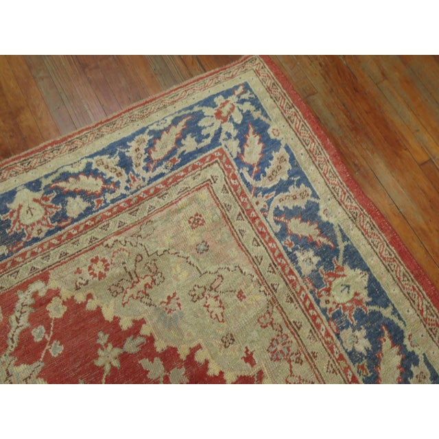 Early 20th-century Turkish Oushak rug with a medallion and border pattern on a red field Measures: 8'9" x 11'9".