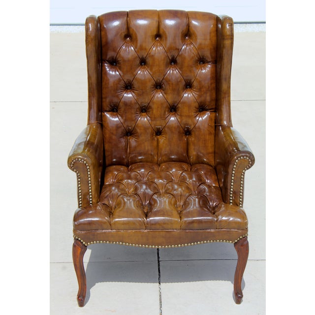 Add timeless character to your home with this vintage Chesterfield-style wingback armchair. Upholstered in rich brown faux...
