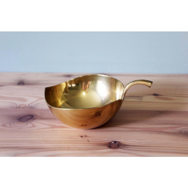 This brass bowl or trinket dish embodies the timeless elegance of classic decorative accessories. Its organic shape,...