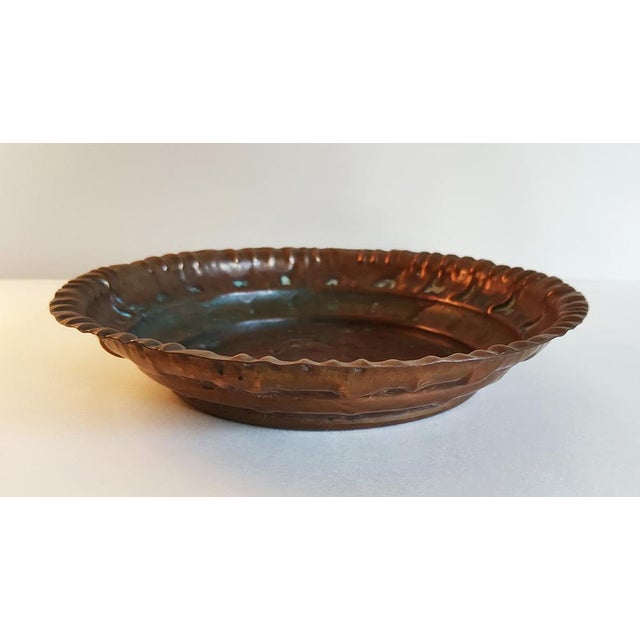 This handcrafted copper bowl displays some blue/green patina and was likely produced in Morocco but the place of origin is...