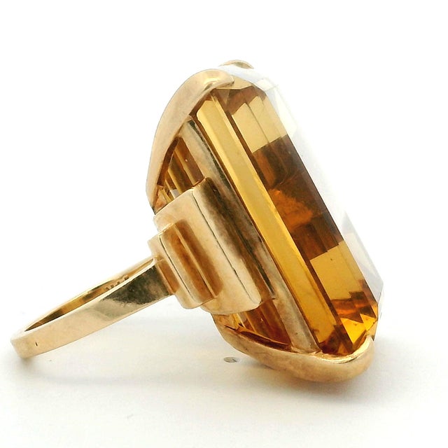 A vintage ring centered with a large emerald-cut citrine glowing in warm golden honey tones. The stone has wonderful depth...