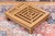A low Japanese elmwood foot stool with a pierced, latticework top carved in a maze-like geometric fretwork pattern and a...