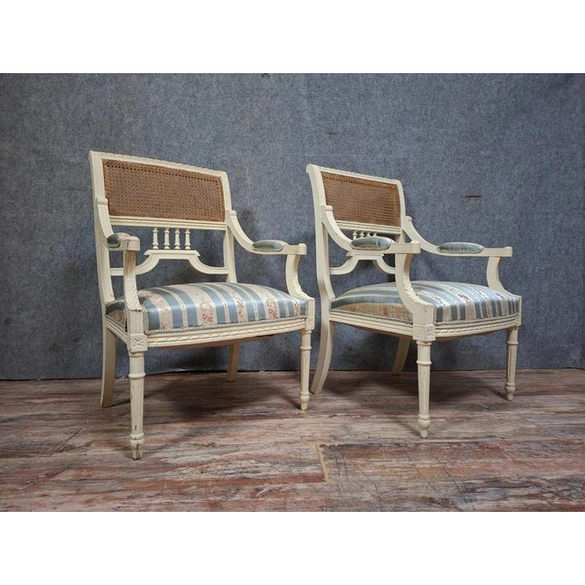 Superb pair of elegant and charming louis xvi style cane armchairs. their painted wooden frames rest on lovely tapered...