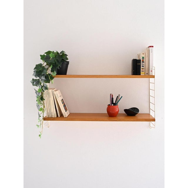 Scandinavian wall shelving system composed of 2 shelves in oak wood and lateral structure in white coated metal. Perfect...