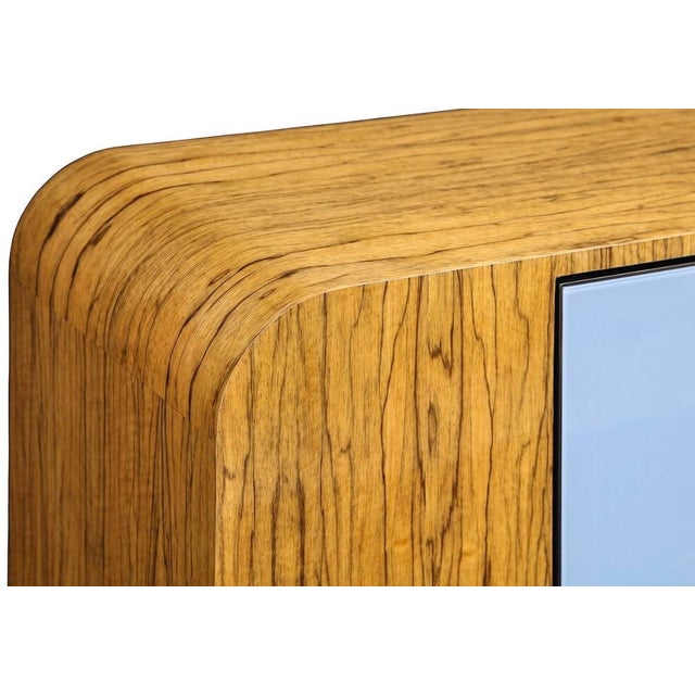 The Ruby cabinet features Black Lima Wood; back painted glass doors in Periwinkle; Anthracite trim, hardware and C shaped...