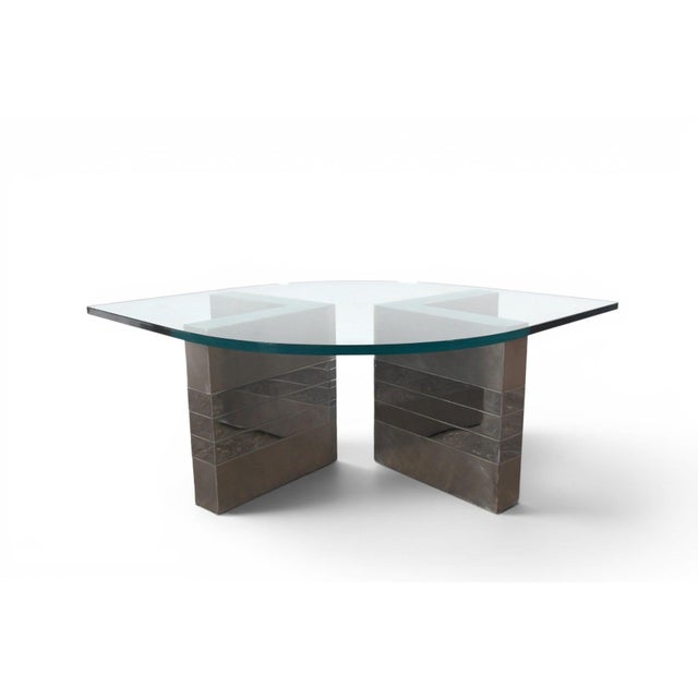 A 1970s coffee table with a polished chrome base and a glass top, reflecting the clean, industrial-glam lines popular in...