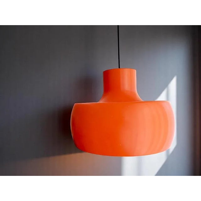 Mid Century Modern large hanging lamp. The lamp is made of 2 metal parts, the outer one is painted orange and the inner...