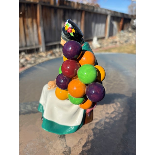 Royal Doulton Old Balloon Seller Figurine HN 1315. Leslie Harrandine is the artist of this figurine and it was issued...