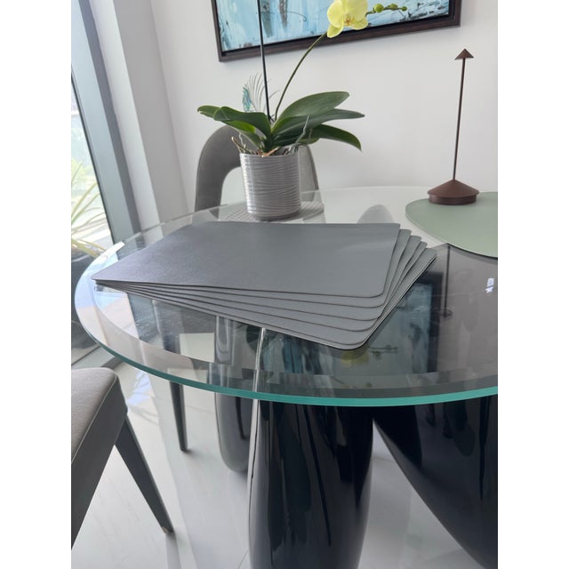 Set of six elegant modern placemats in a refined gray tone with a soft textured surface that closely resembles natural...