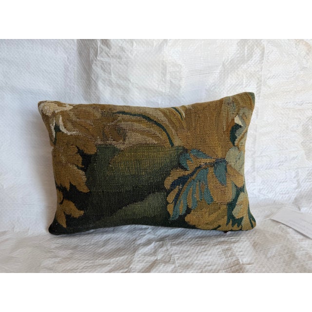 Antique 17th century Flemish verdure tapestry pillow showcasing a softly faded floral and foliate design woven with...
