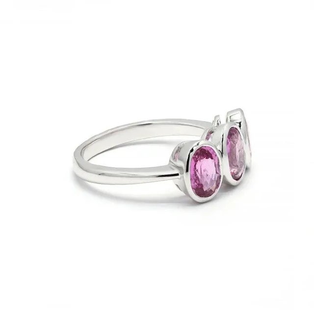 This exquisite 18K gold three-stone ring set with pink sapphire gemstones wonderfully complements your style. Deeper...