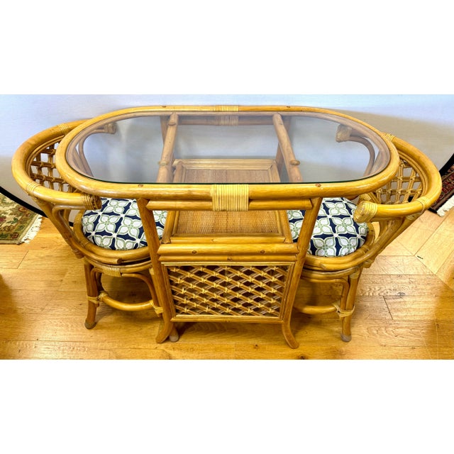 This charming 3-piece vintage bamboo and rattan honeymoon bistro set features two swivel chairs and a matching glass-top...