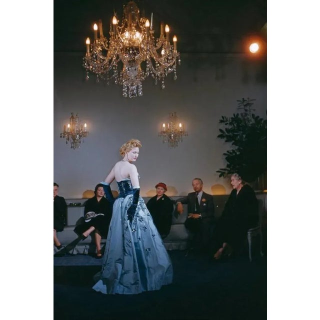 Fashion At Hartnell’s 1955 by Slim Aarons Slim Aarons Limited Estate Edition A fashion show at the Burton Street salon of...