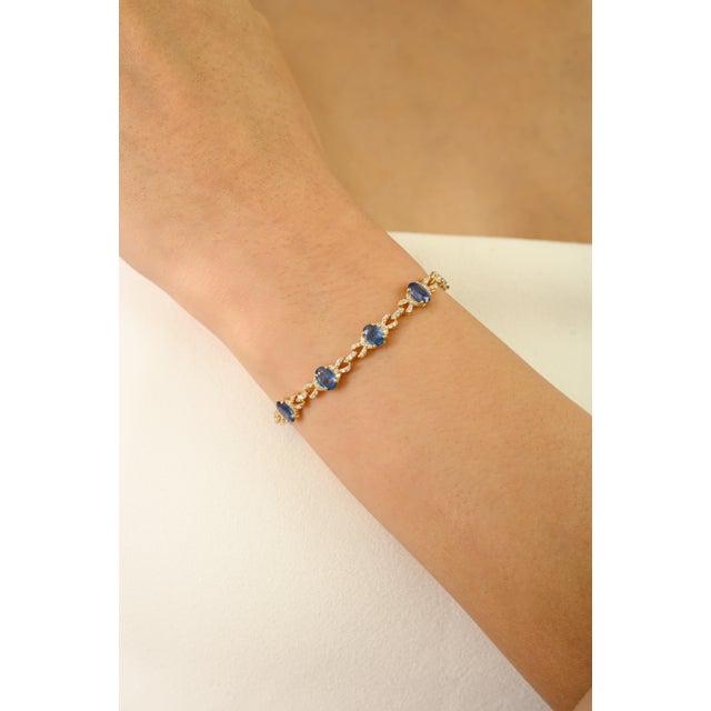 This tennis bracelet features 12 oval cut blue sapphires totaling 6.54 carats, set in rich 14k yellow gold. Each sapphire...