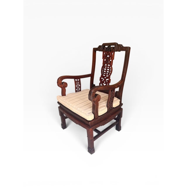 A beautifully crafted vintage Chinoiserie horseshoe armchair featuring an intricately carved openwork back with...