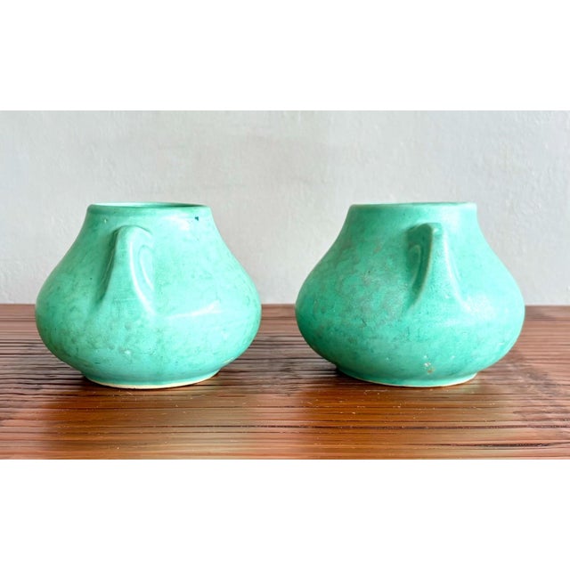 This is a pair of vintage ceramic vessels with a soft matte turquoise glaze, likely early to mid-20th century American art...