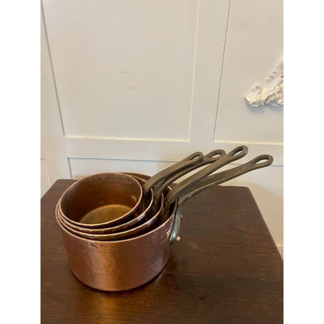 Antique George III set of four copper pans of circular form having a tempered copper base, iron handles with copper rivets...