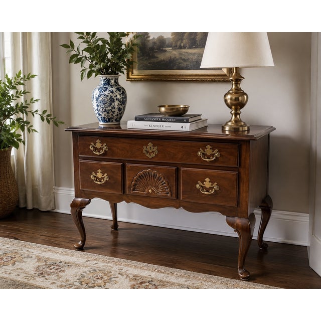 Elegant vintage lowboy by Drexel featuring rich walnut veneers, classic cabriole legs, brass batwing hardware, and a...