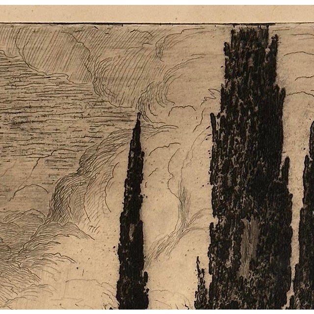 A striking early 20th-century French etching depicting a tranquil lakeside landscape framed by dramatic cypress trees...