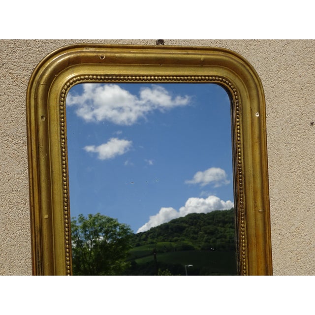 Mid-19th-century mirror, Louis Philippe period and style. Wooden structure, wooden frame with gilt stucco. Gilt frame,...