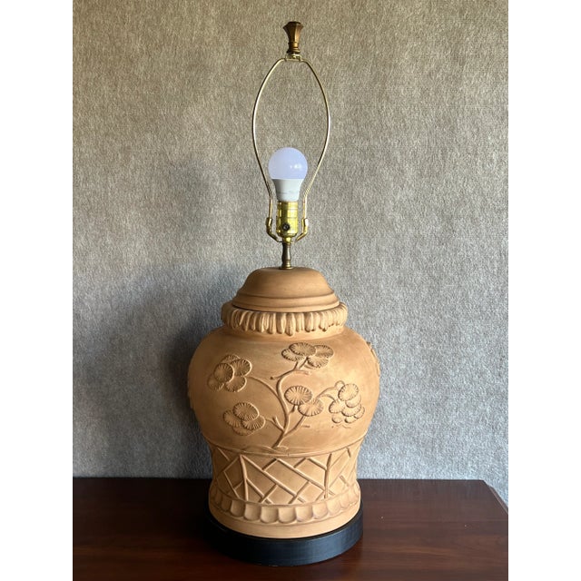 Vintage Late 20th Century Chinoiserie Style terracotta pottery lamp featuring trees and lattice work relief and a black...