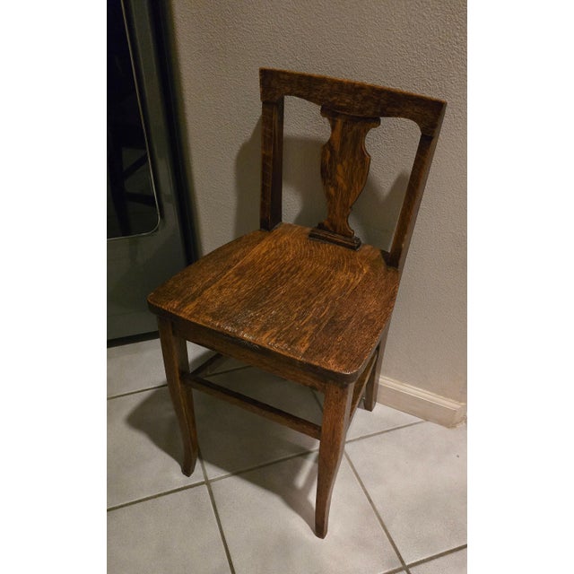 This is an early 20th-century antique American oak children's "T-back" or "vase-back" country kitchen side chair,...