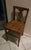 This is an early 20th-century antique American oak children's "T-back" or "vase-back" country kitchen side chair,...