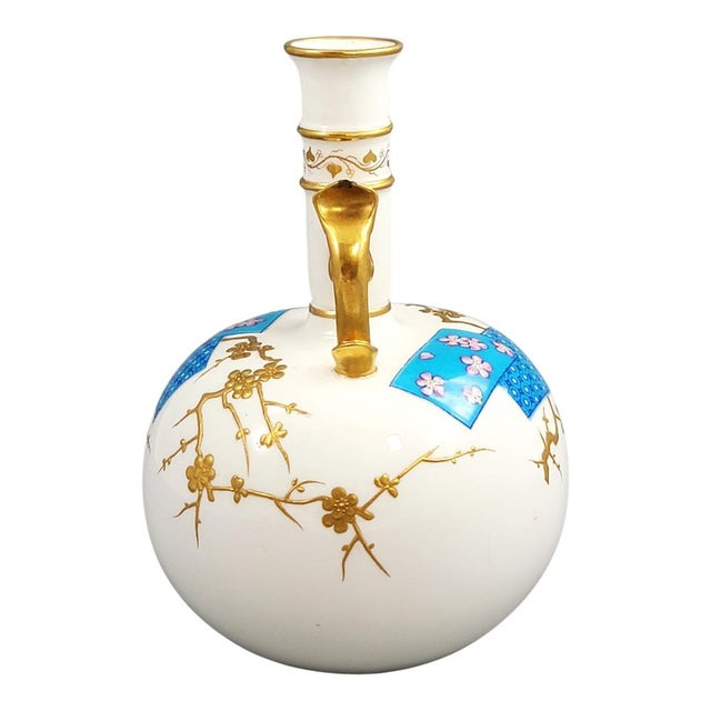 A finely balanced porcelain vase by Minton in elegant bottle form, decorated with raised gilt prunus branches standing in...