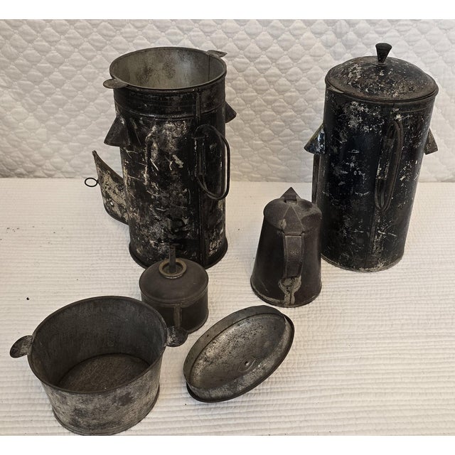 A rare grouping of two antique American tin tea warmers accompanied by a matching period tin pitcher. The tea warmers are...