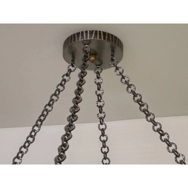 A large hand-forged wrought iron chandelier decorated with textures motif designs (36 inches in diameter, height...